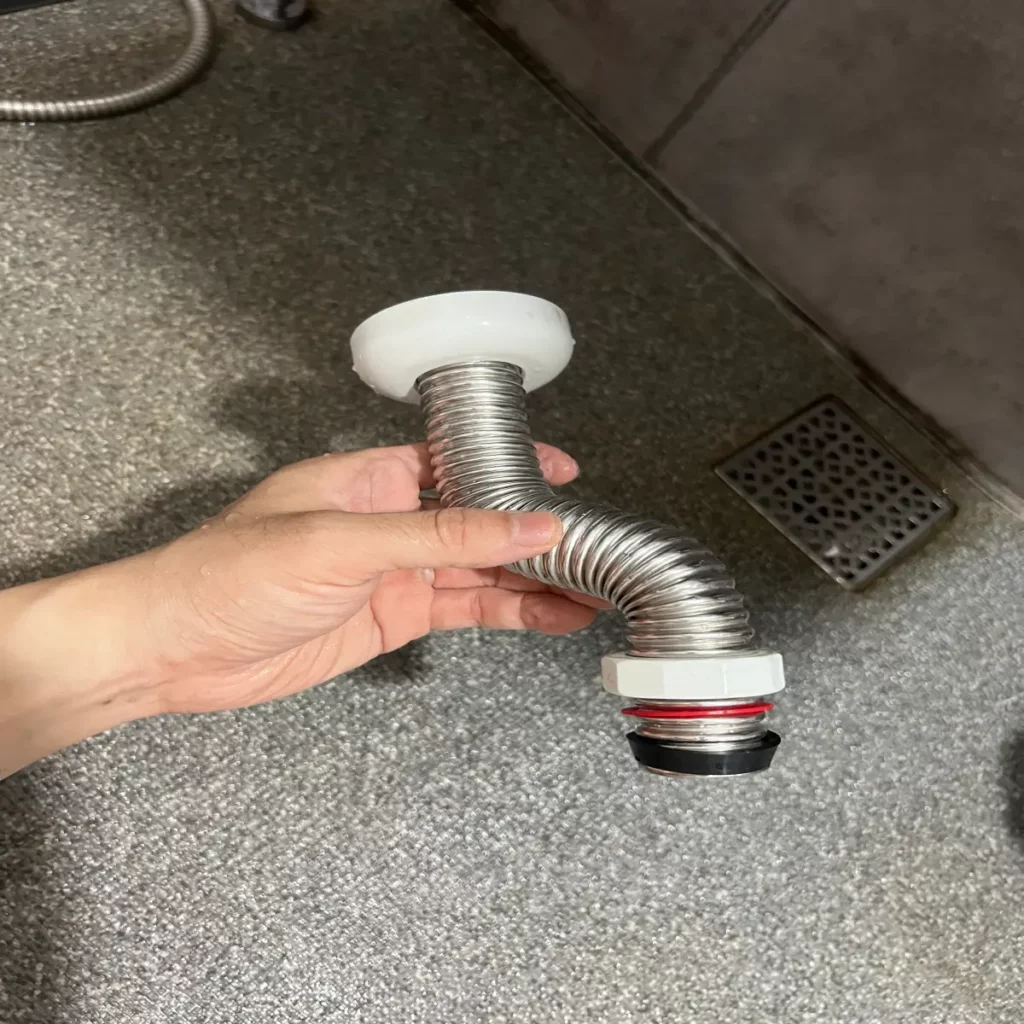 벽에-고정되어있는-싱크호스를-해체한-모습