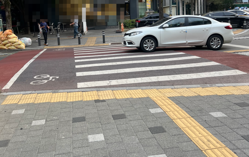 자전거표시가 있는 횡단보도에서 자동차가 지나가고있는 사진
