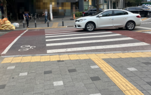 자전거표시가 있는 횡단보도에서 자동차가 지나가고있는 사진